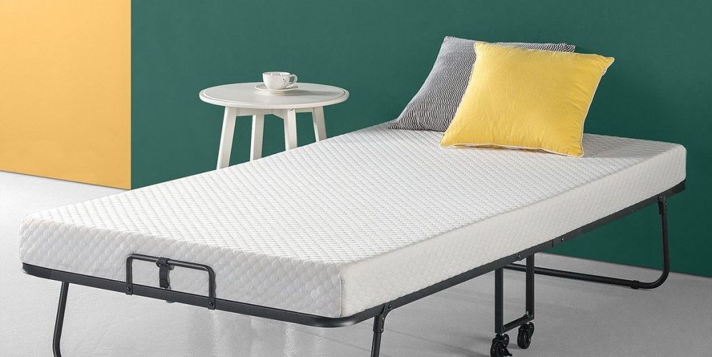 Geopende vouwbed in slaapkamer als voorbeeld voor het vergelijken van vouwbedden op maat en comfort