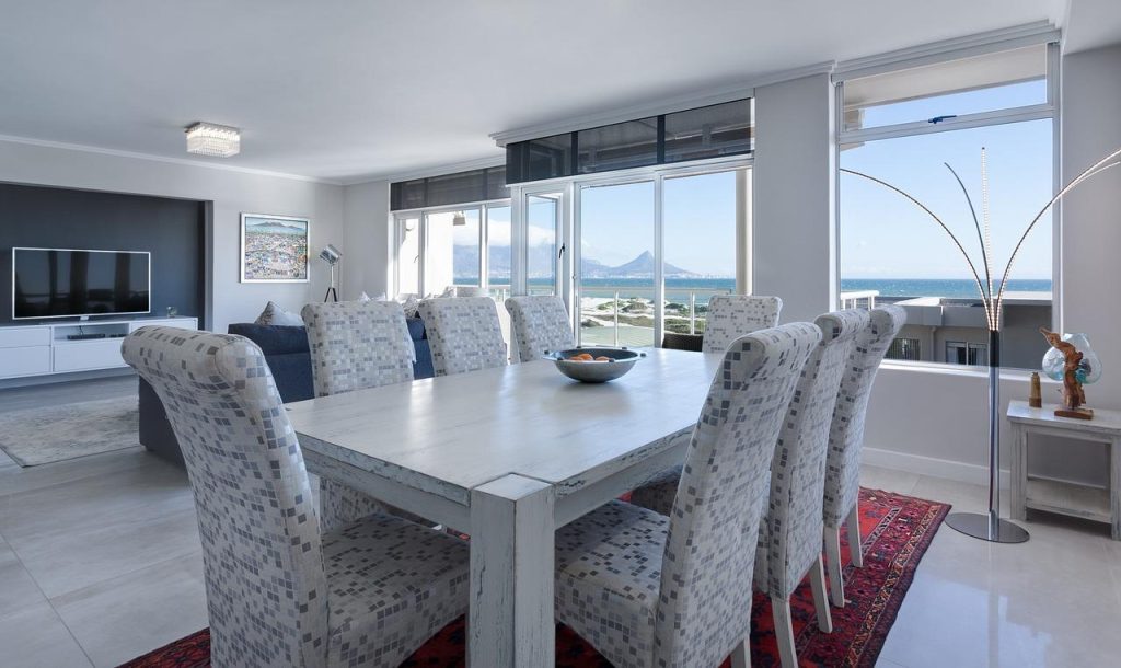 Stijlvolle eetkamer met luxe velours eetkamerstoelen in warme tinten rond houten eettafel